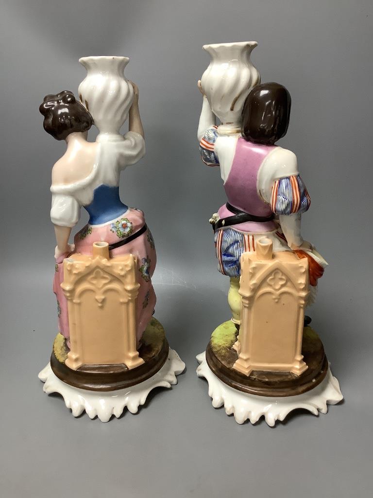 A pair of Italian porcelain figures and a pair of Continental figural candlesticks